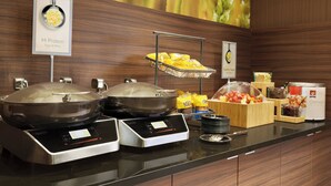 A buffet setup with two hot plates, a fruit display, and a sign indicating 'Hi Protein' with eggs and more. - Fairfield Inn by Marriott Philadelphia Valley Forge (King of Prussia)