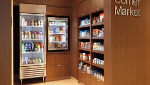 A grocery store interior with wooden shelving stocked with various food items and a refrigerated section. - Fairfield Inn by Marriott Philadelphia Valley Forge (King of Prussia)