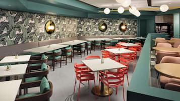 A restaurant with a long counter, multiple tables, and chairs.