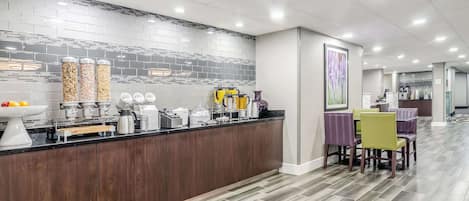 A modern kitchen with a black countertop, stainless steel appliances, and a tiled backsplash.