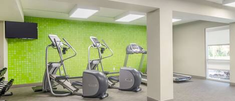 A fitness center with treadmills, a stationary bike, and a wall-mounted TV.