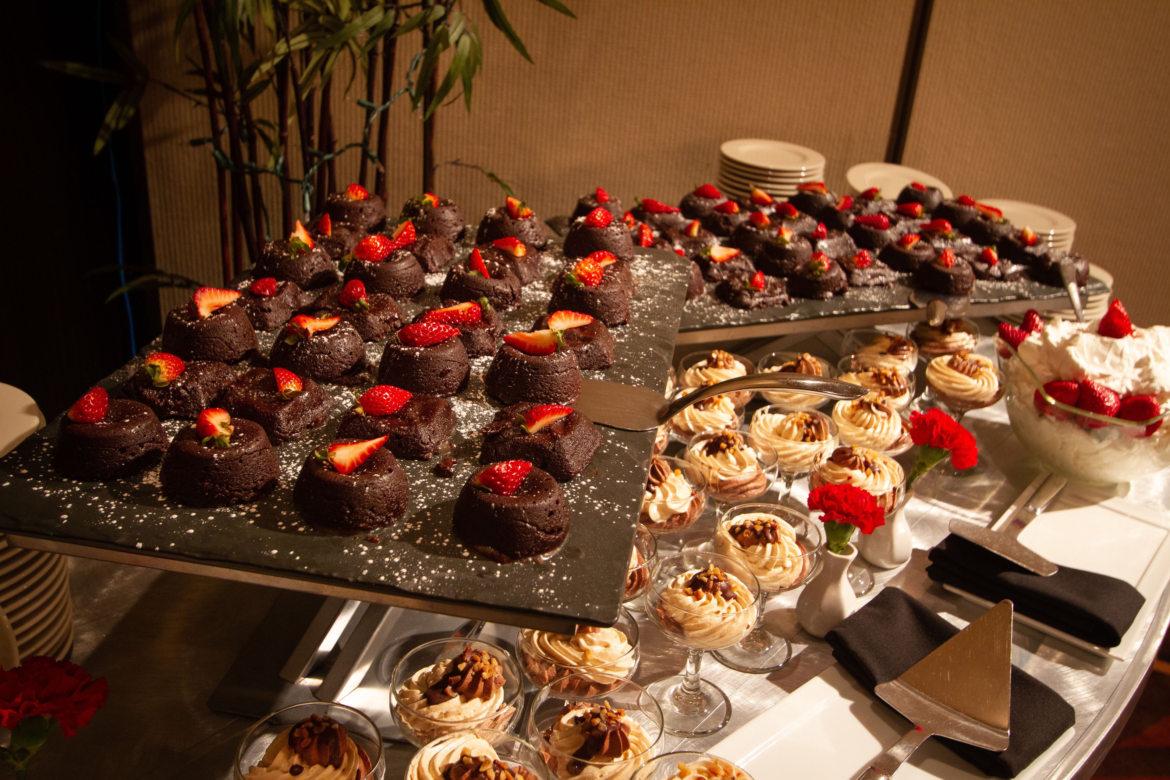 A buffet with various desserts including chocolate cakes and cream-filled pastries.