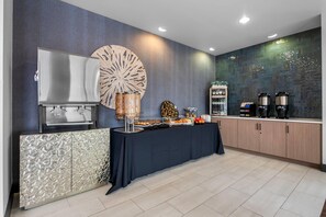 Een moderne keuken met een buffetopstelling, een decoratief kunstwerk en een koffiehoek.