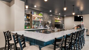 Een moderne keuken met een groot schiereiland, een bar en zitplaatsen.