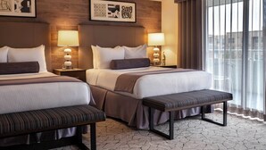 A hotel room with two beds, a bench, bedside lamps, and artwork on the walls. - Warwick Denver (Denver)