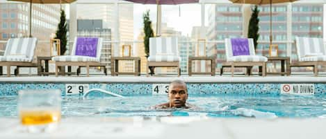 Una piscina al aire libre, una piscina climatizada, sombrillas