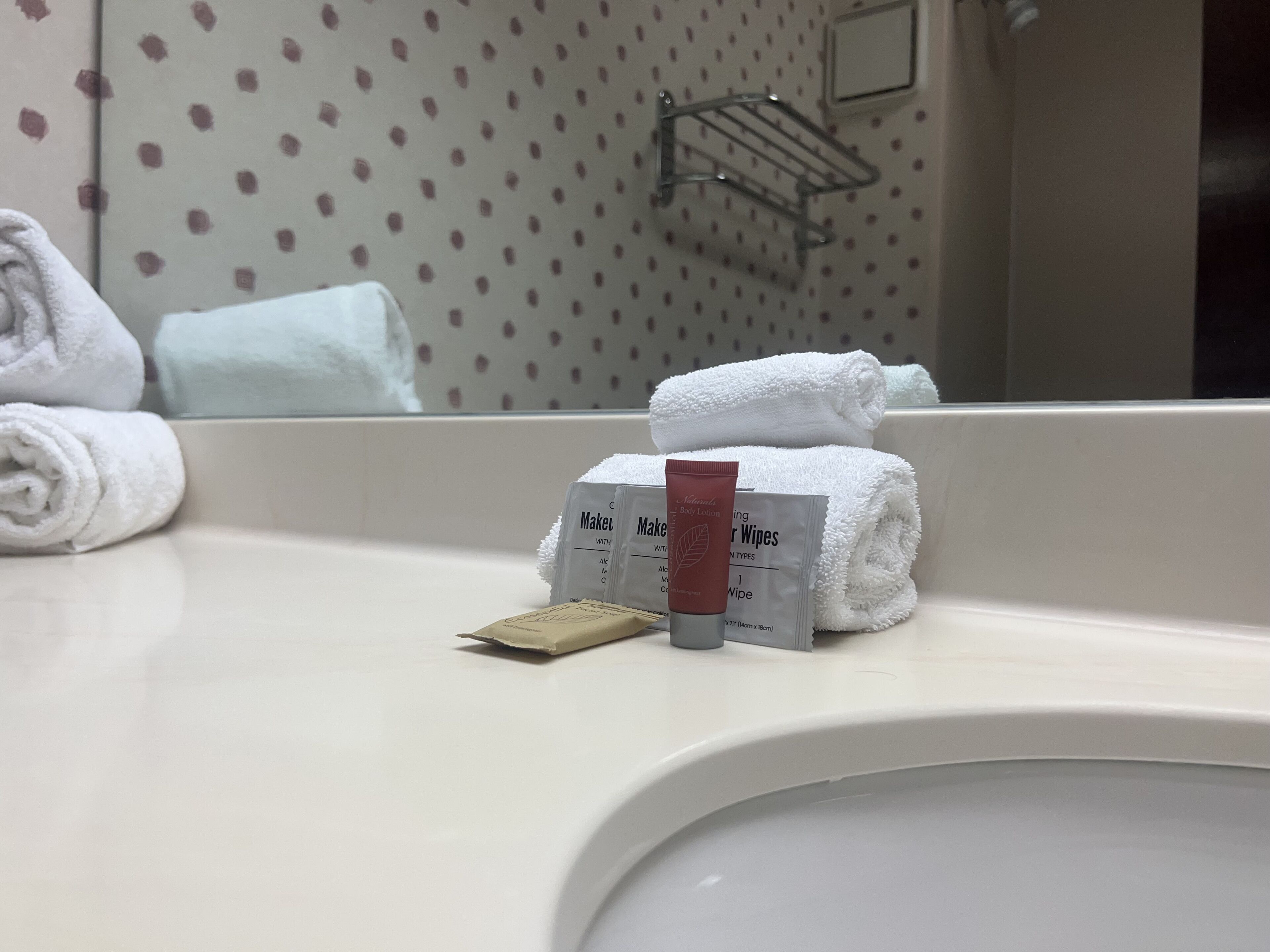 Ein Waschbecken mit Pflegeprodukten, darunter eine Tube Körperlotion, eine Seife und ein Handtuch.