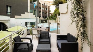 Un espace extérieur aménagé avec des meubles en osier et une piscine.