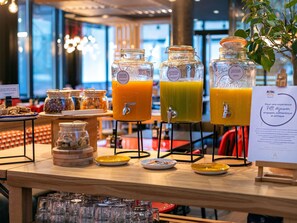 A breakfast buffet with various food items and three beverage dispensers. - Novotel Lyon Bron Eurexpo (Bron)
