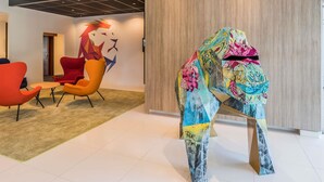 Un interior moderno con techo curvo, un revestimiento de pared de madera y arte abstracto colorido.