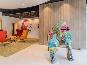 Ein modernes Interieur mit gewölbter Decke, einer Holzwand und farbenfroher abstrakter Kunst.