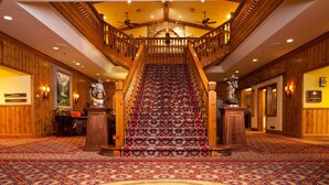 Una imponente escalera con alfombra estampada y barandales de madera.