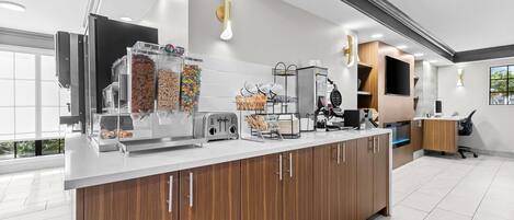 Una cocina moderna con una isla central, electrodomésticos integrados y un amplio ventanal.
