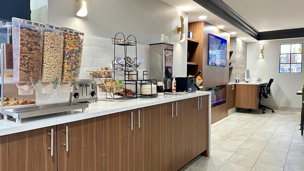 Una cocina moderna con barra desayunadora, dispensadores de cereal y estación de café.