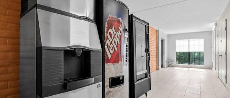A commercial kitchen with two large appliances, a brick wall, and a large window.