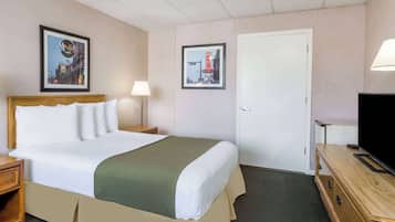 A hotel room with a bed, bedside tables, a TV, and framed pictures on the walls.