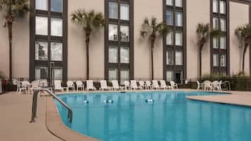 Alberca al aire libre y camastros