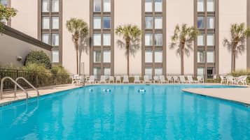 Een buitenzwembad en ligstoelen