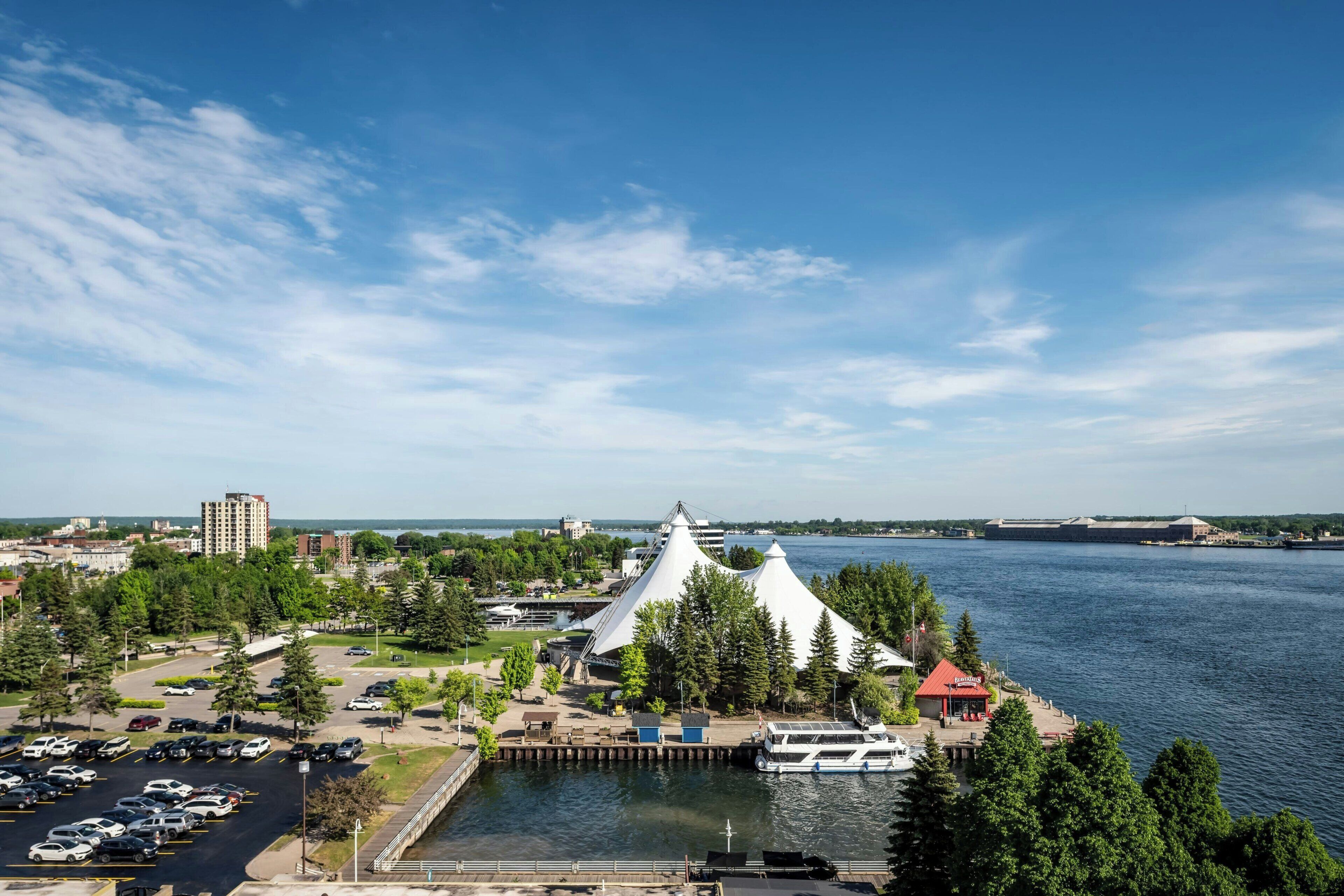 A waterfront property with a dock, a boat, and a building with a distinctive white roof.