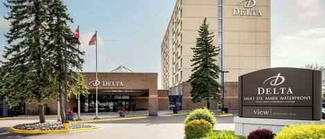 A Delta hotel entrance with a sign for the Saulte Ste. Marie Waterfront Hotel and Conference Centre.