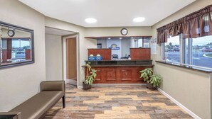 A reception area with a wooden counter, a bench, and potted plants. - Days Inn by Wyndham Clarksville TN (Clarksville)