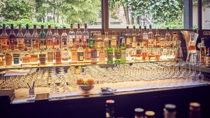 Un bar con una variedad de botellas de licor y vasos.