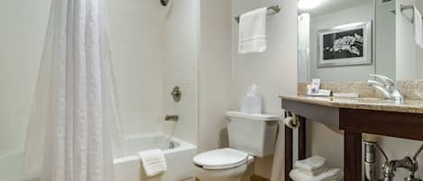 A bathroom with a shower, toilet, and sink.