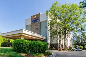 A Comfort Inn hotel with a modern facade, a covered entrance, and well-maintained landscaping. - Comfort Inn Raleigh Midtown (Raleigh)