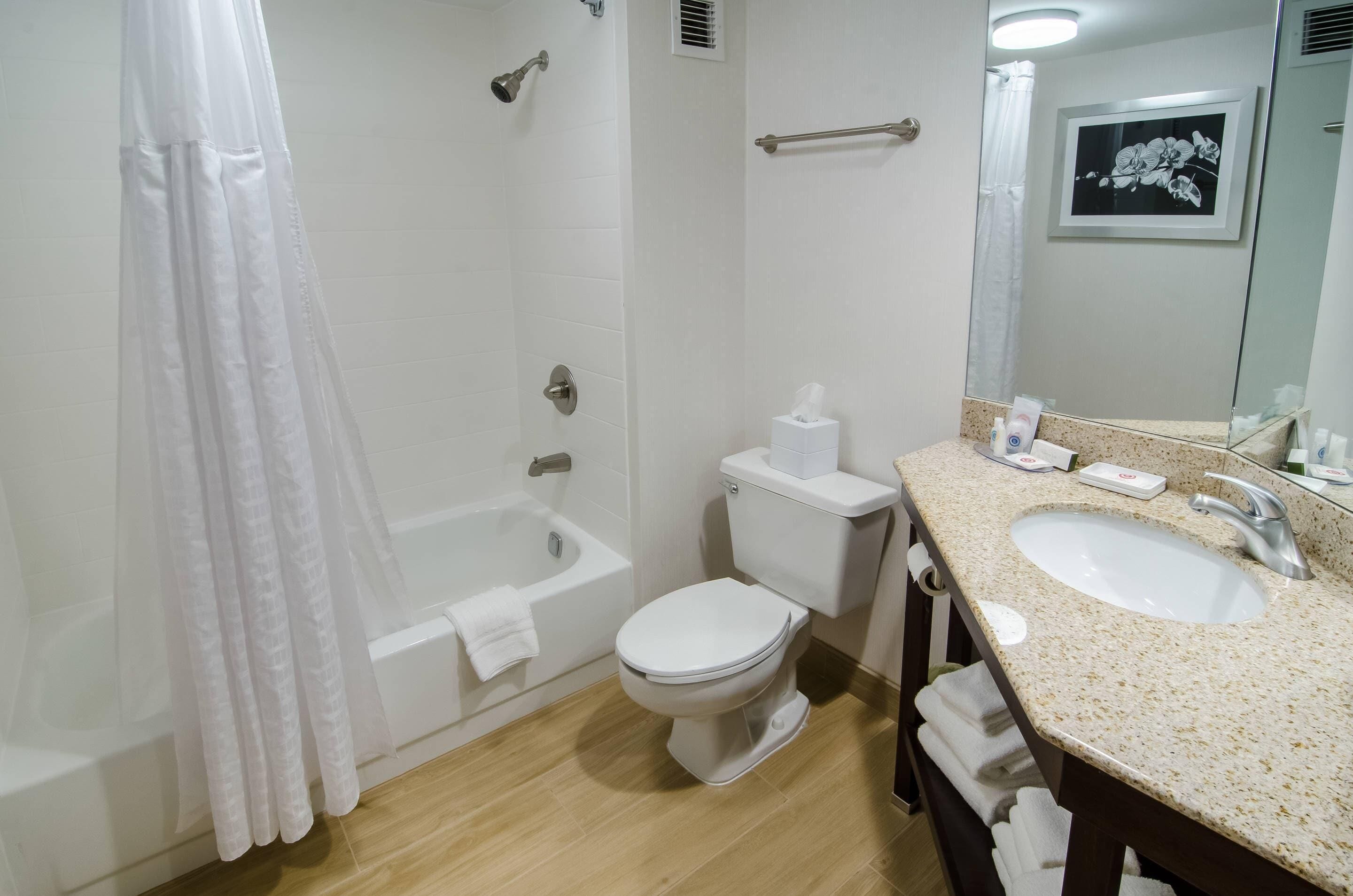 Un baño con bañera, inodoro y lavamanos.