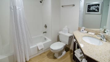 Un baño con bañera, inodoro y lavamanos.