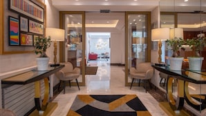A modern hotel lobby with a central seating area, glass partitions, and a geometric patterned rug. - Atlantic Hotel (Paris)