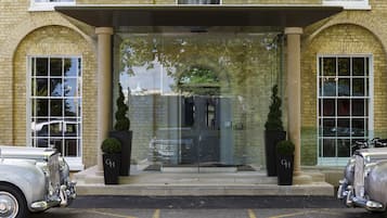 A classic building with a grand entrance, two large columns, and a glass door.