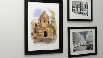 Drie ingelijste kunstwerken aan een muur.