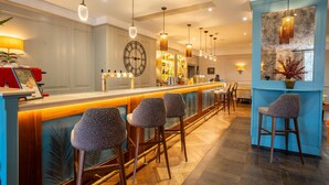 A bar area with a wooden counter, leopard print stools, and a clock on the wall. - The Gonville Hotel, a member of Radisson Individuals (Cambridge)