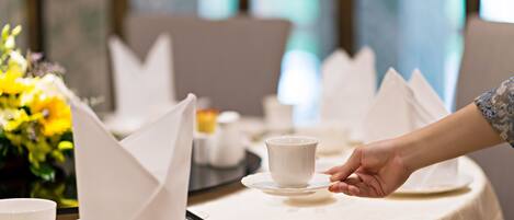 Una mesa servida para una comida, con servilletas blancas, una taza y un tazón.