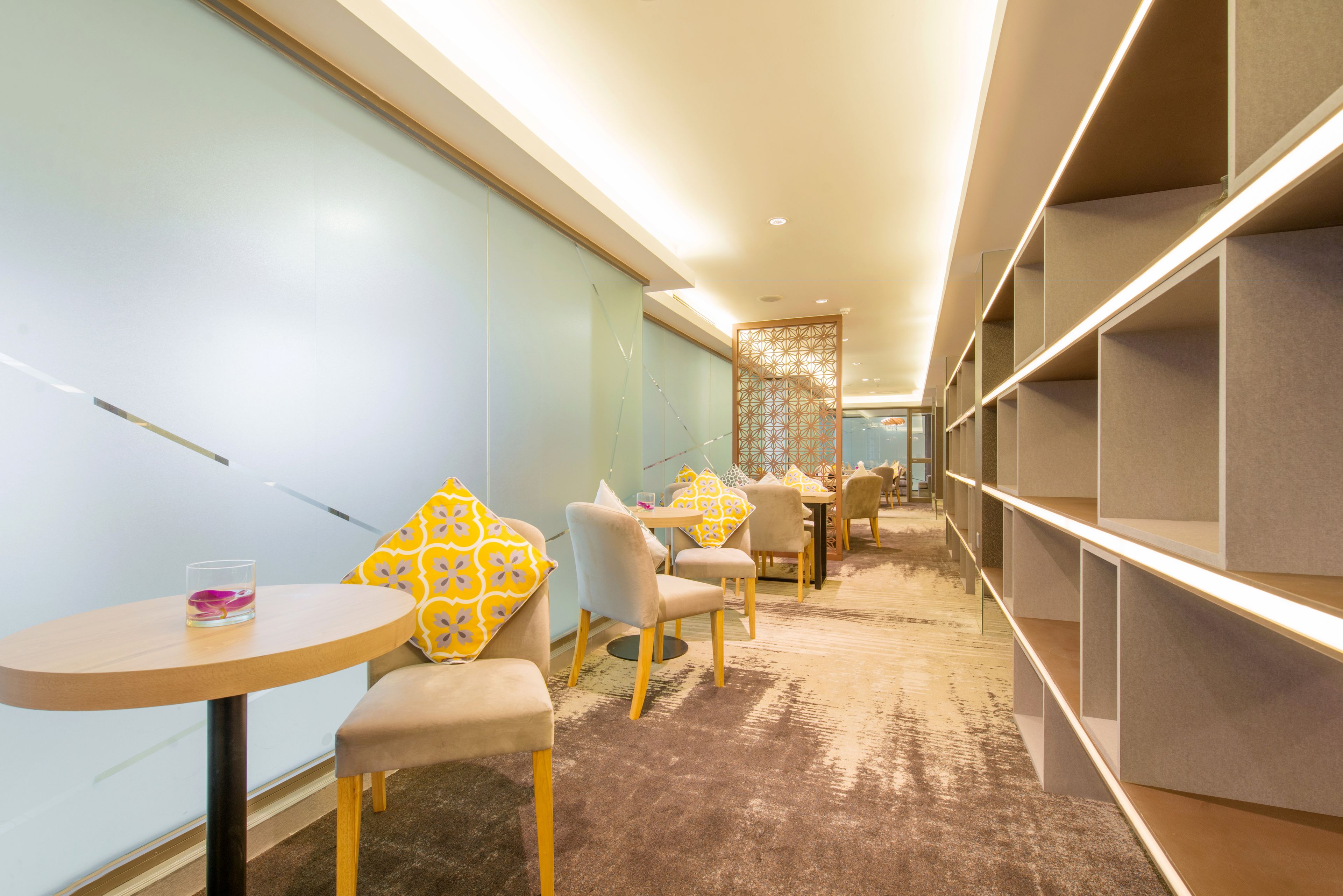 A hotel lobby with seating areas, a reception desk, and a decorative wall.