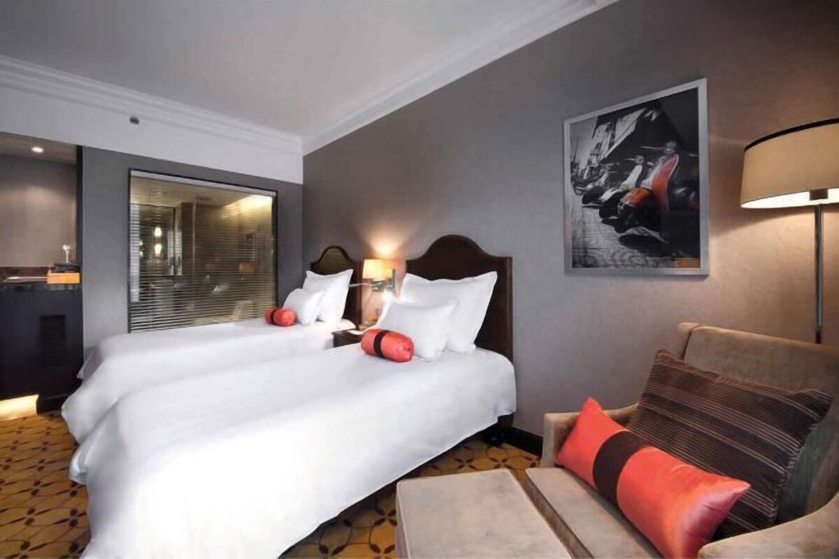Ein Hotelzimmer mit einem großen Bett, einer Couch, einem Schreibtisch und einer Lampe.