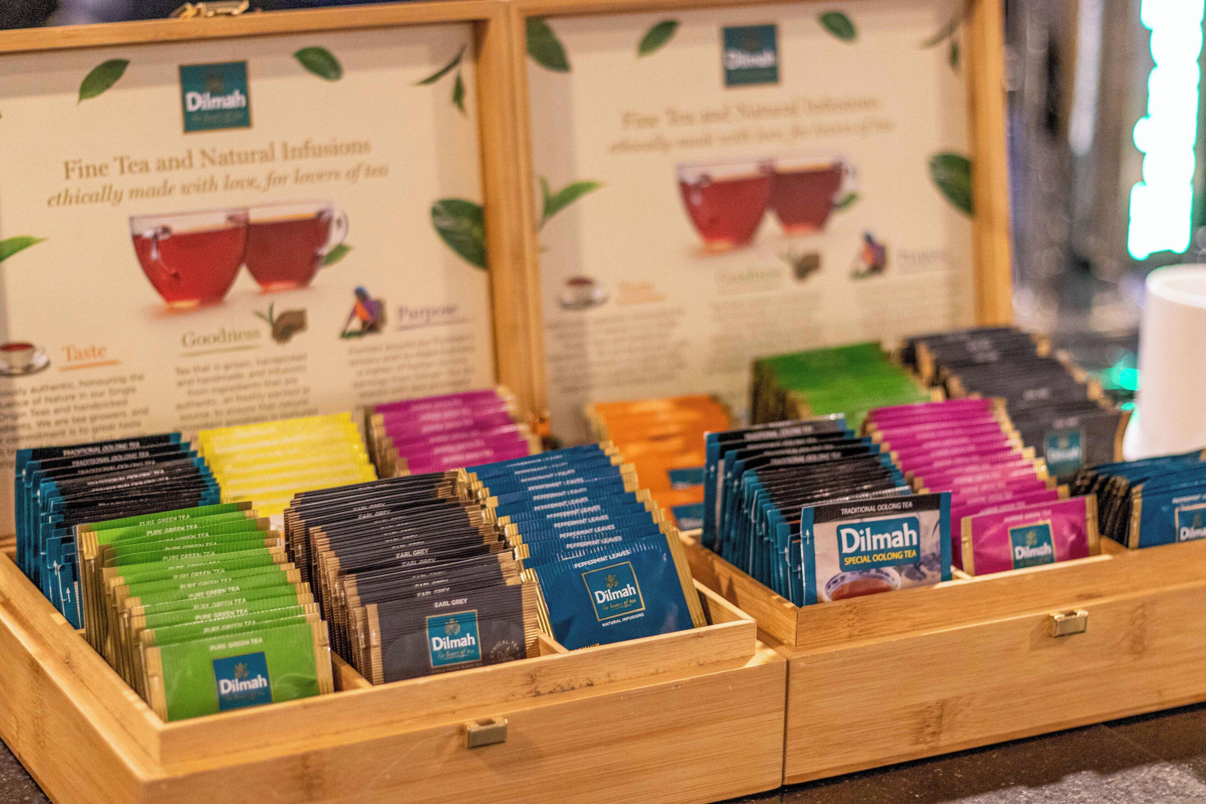 Varias marcas de té expuestas en cajas de madera, cada una con el nombre de la marca.