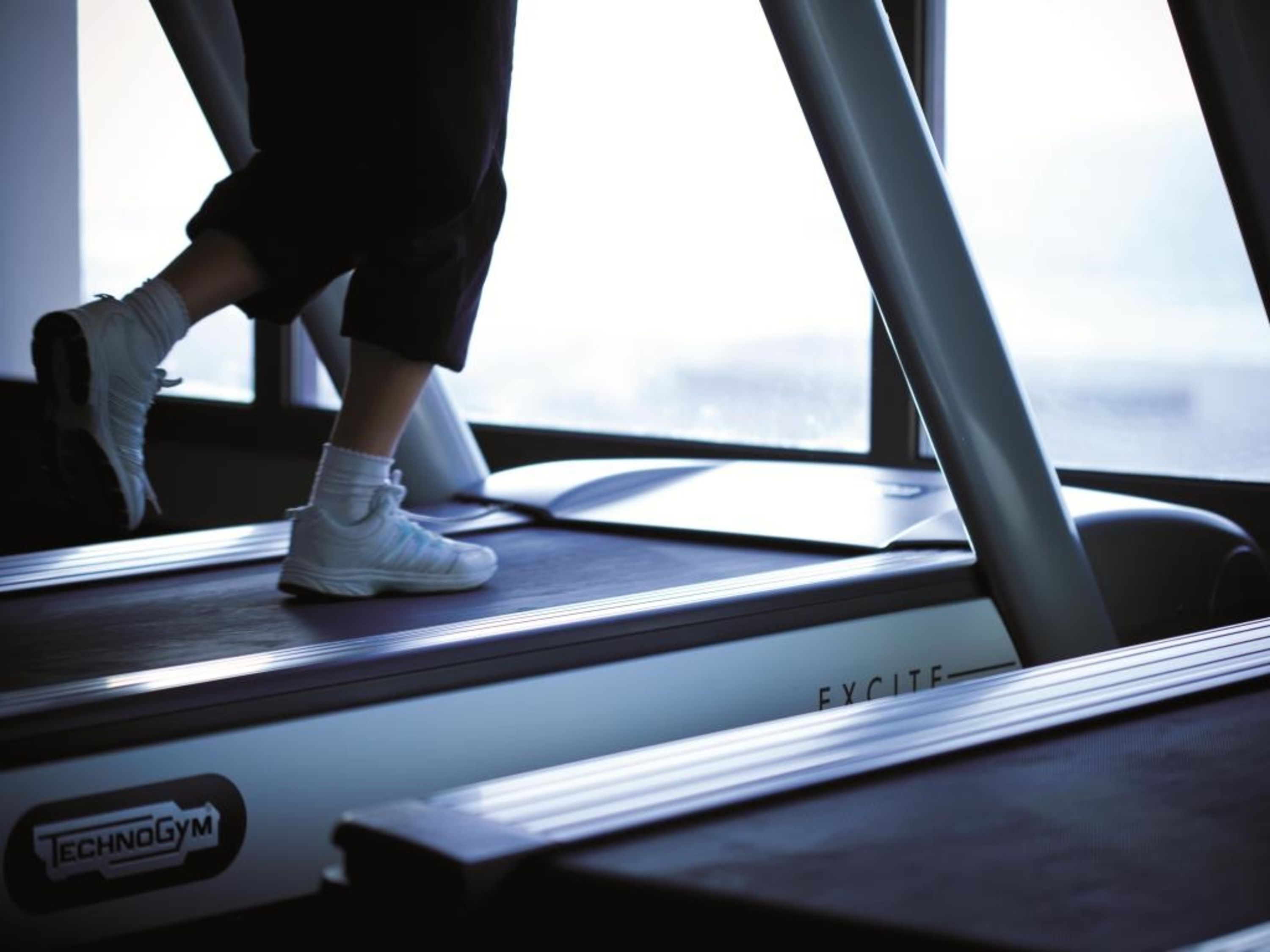 A treadmill with the brand name "TECHNOGYM" visible.