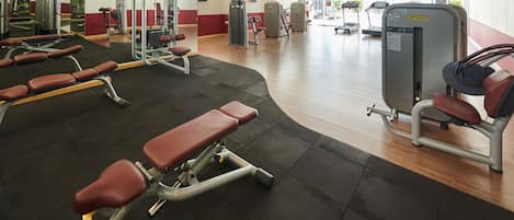 A gym with various exercise equipment, including benches and weight machines.