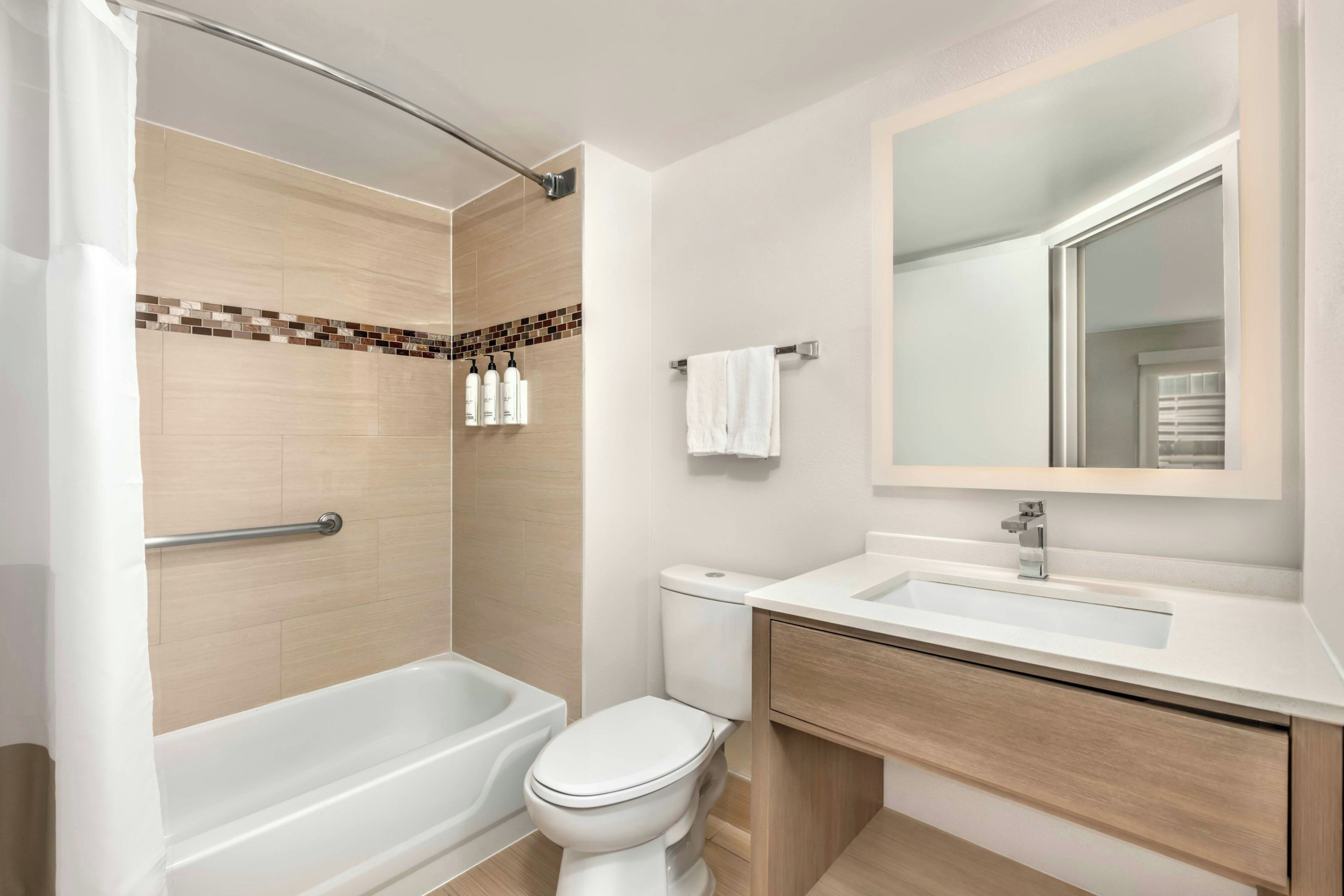 Een moderne badkamer met een bad, toilet en wastafel.