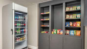 Ein Getränkeautomat mit einer Auswahl an Getränken und Snacks, darunter Chips und salzige Snacks.