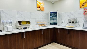 A modern kitchen with marble backsplash, wooden cabinets, and a coffee machine.