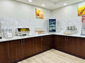 A modern kitchen with marble backsplash, wooden cabinets, and a coffee machine. - City Express by Marriott I-10 West Energy Corridor (Houston)