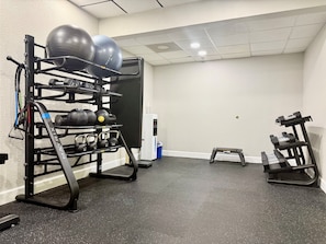 A gym with exercise equipment including a pull-up bar, kettlebells, and a step platform. - City Express by Marriott I-10 West Energy Corridor (Houston)