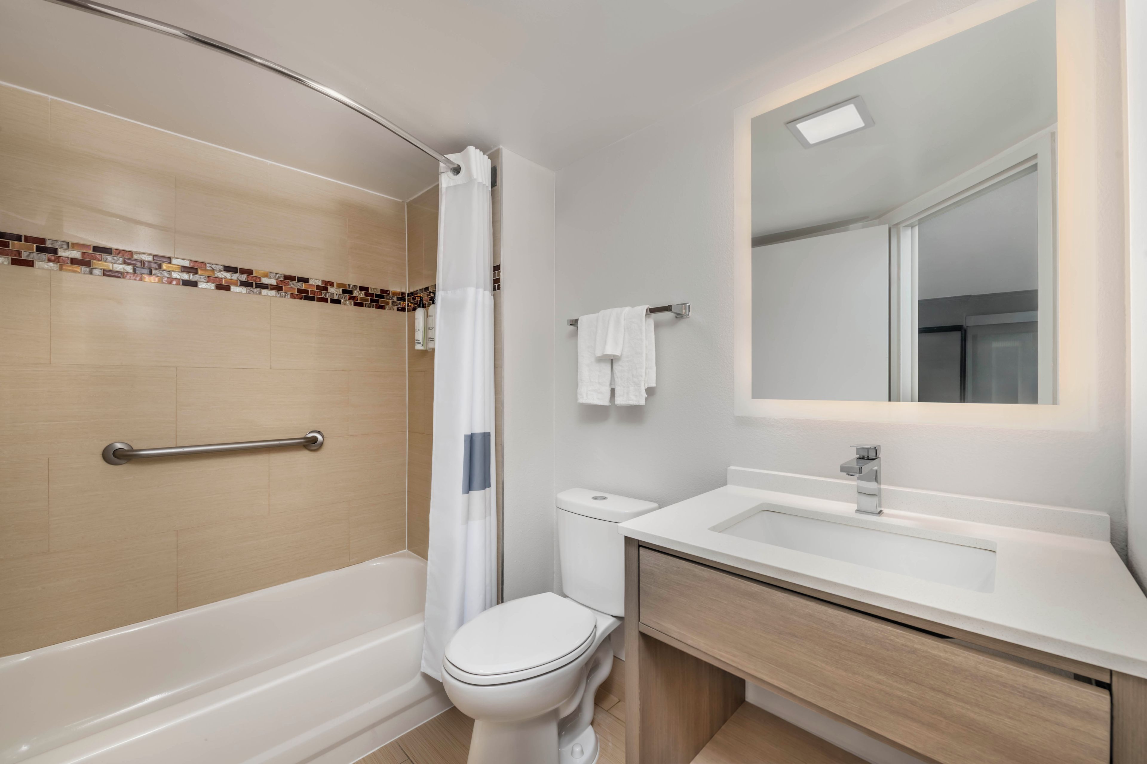 A modern bathroom with a shower, toilet, and sink.
