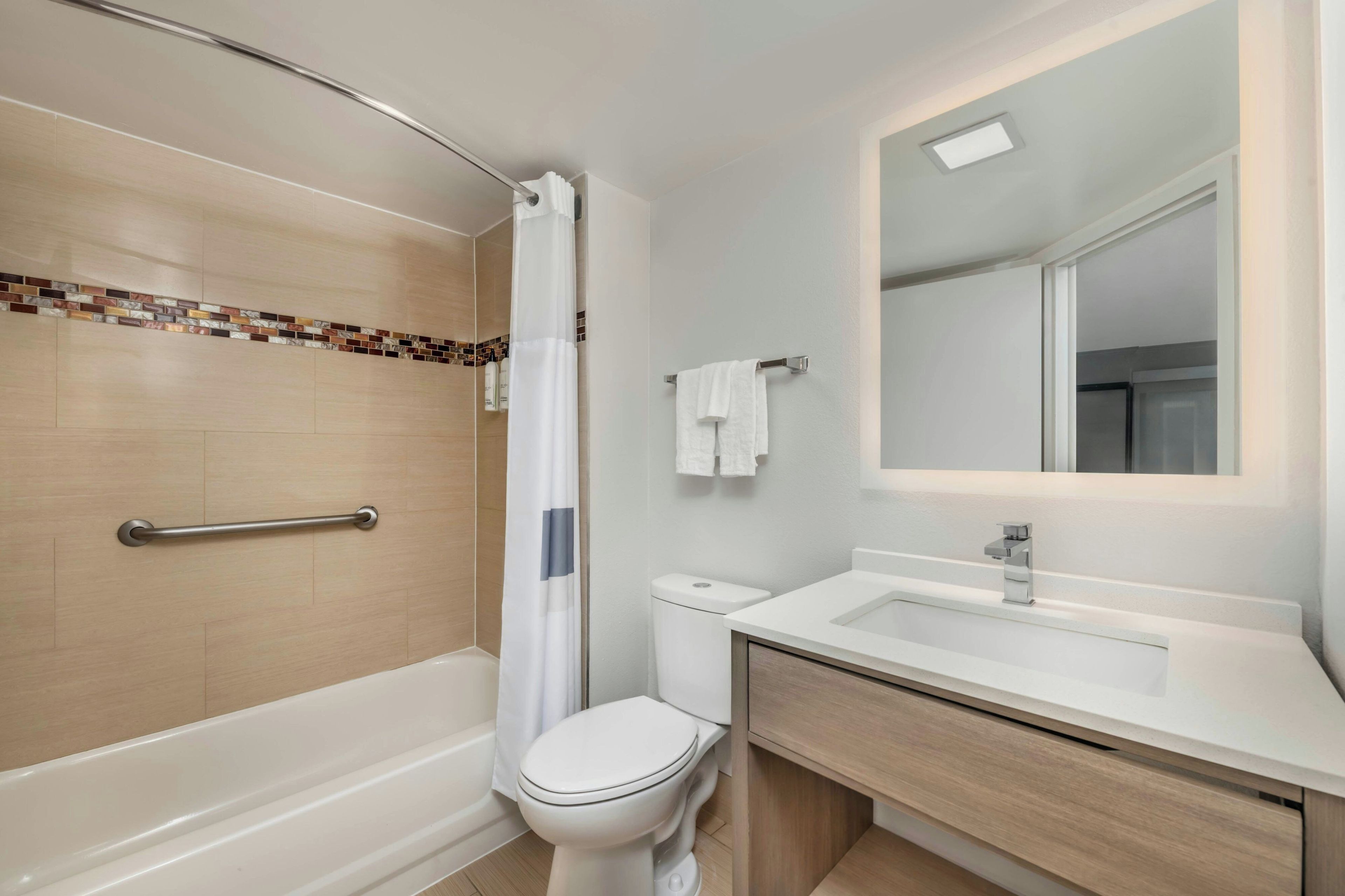 A modern bathroom with a shower, toilet, and sink.