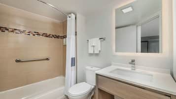 A modern bathroom with a shower, toilet, and sink.
