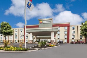 Un hotel Comfort Inn & Suites con estacionamiento y un asta de bandera.