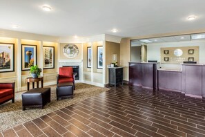 Eine Hotelhalle mit Rezeption, Sitzgelegenheiten und Kamin.